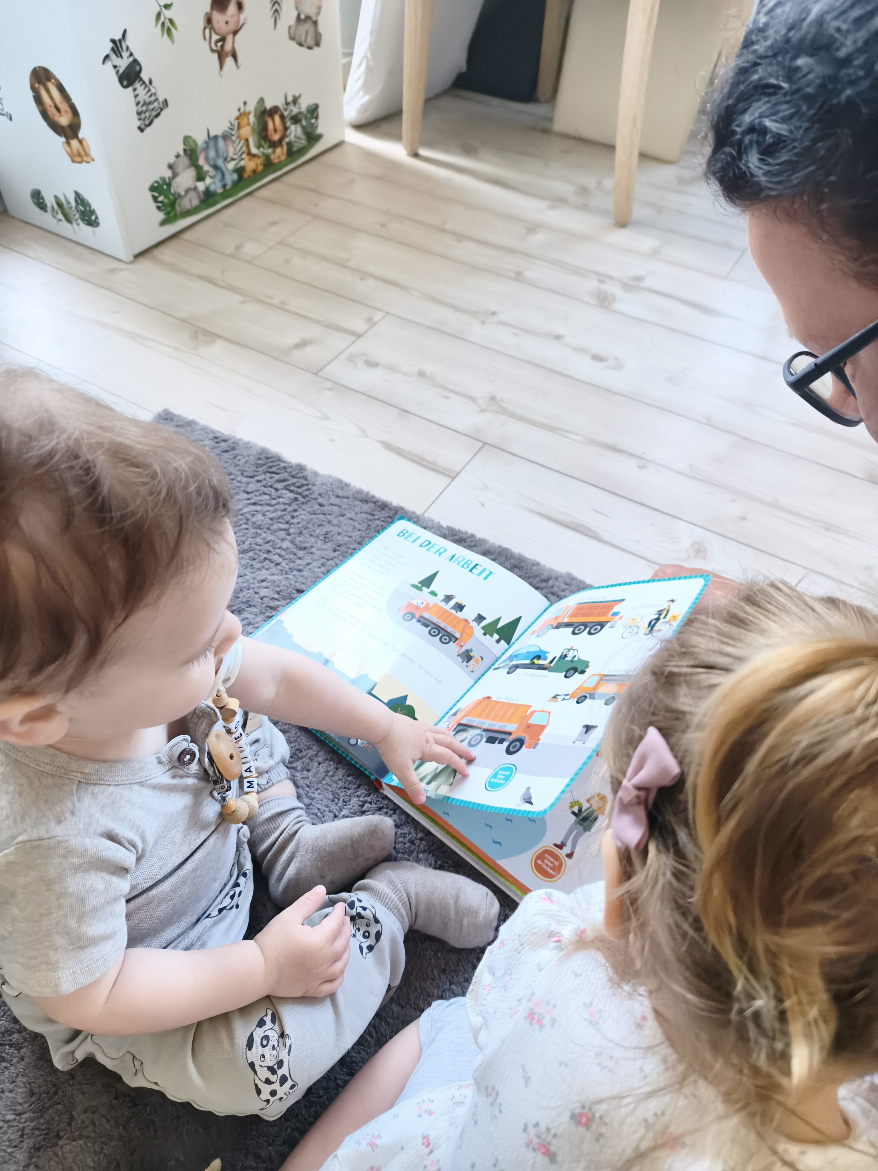 Zwei Kleinkinder betrachten gemeinsam ein Bilderbuch